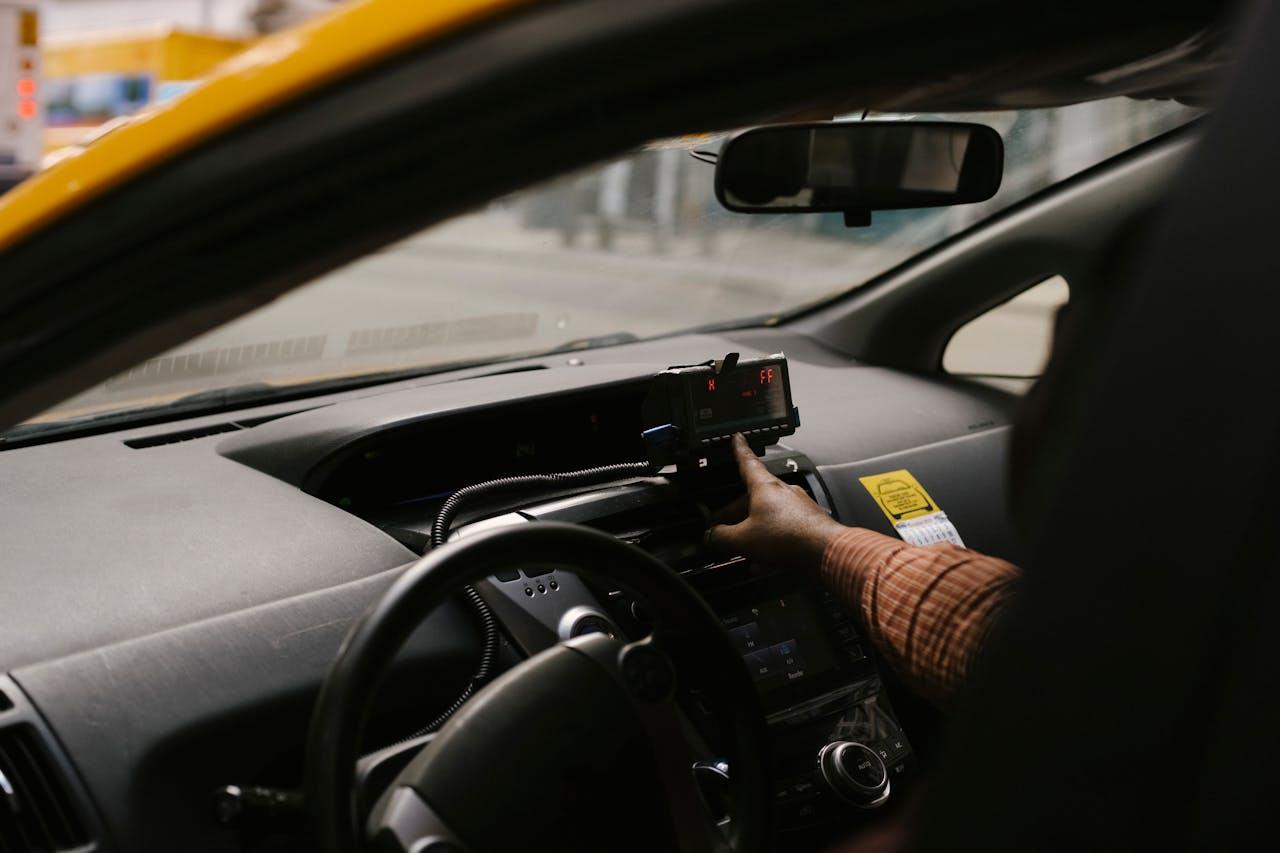 Crop ethnic man with navigator in taxi